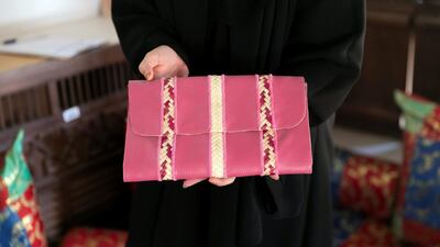 Some crafts feature several traditional techniques, such as this camel leather bag with khoos palm fronds. Reem Mohammed / The National