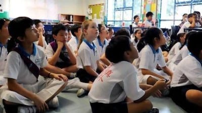 Happy Rogers, centre, the daughter of the billionaire US investor Jim Rogers, listens attentively to her Chinese teacher in her Mandarin class at Nanyang Primary School in Singapore. Mr Rogers believes young people the world over should prepare for the future by learning Mandarin. Simin Wang / AFP