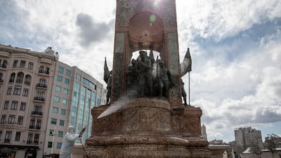 An employee from Istanbul Municipality disinfects the Taksim Republic Statue in Taksim square to prevent the spread of the COVID-19, coronavirus. Getty