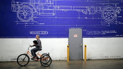 An employee rides a bicycle past a mural at the Mack Truck Inc. cab and vehicle assembly plant in Macungie, Pennsylvania, U.S., on Thursday, Dec. 10, 2015. The U.S. Federal Reserve is scheduled to release industrial production figures on December 16. Photographer: Luke Sharrett/Bloomberg