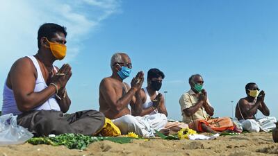 Hindu devotees offer food and prayers as they perform 'Tarpan' rituals that are believed to ensure peace and happiness to the souls of one's ancestors, at Marina beach in Chennai. AFP