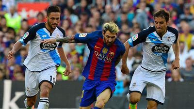Barcelona’s Argentine forward Lionel Messi, centre, vies with Deportivo’s Romanian forward Florin Andone. Lluis Gene / AFP