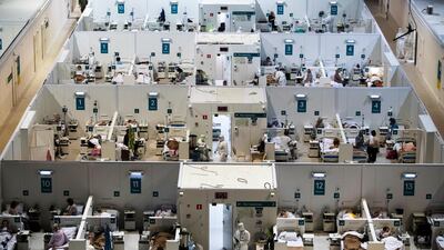 Medical workers and patients are seen in the treatment hall of a temporary hospital in Moscow, Russia. AP Photo
