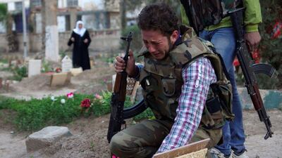A Syrian rebel fighter mourns at the grave of his father who was killed in shelling by government forces in Deir Ezzor in March 2013. Reuters