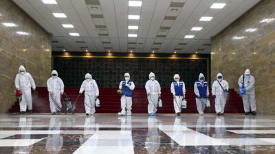 Workers from the South Korea Pest Control Association spray disinfectant as part of preventative measures against the spread of coronavirus at the National Assembly. AFP