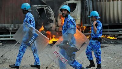 Security forces make their way on September 12, 2016, past burning vehicles, which were set on fire by protesters in Bengaluru after India’s Supreme Court ordered Karnataka state to release water daily from the Cauvery river to neighbouring Tamil Nadu. Abhishek N. Chinnappa / Reuters