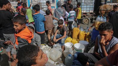 Displaced Palestinians wait to collect desalinated water in the Al Mawasi district of Khan Younis in southern Gaza. Bloomberg