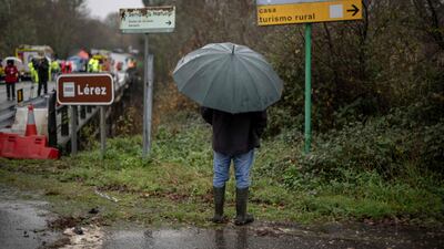 A resident looks on as emergency services work on a bridge above the Lerez river. AFP
