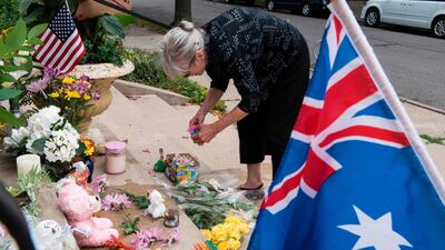 Nancy Coune, administrator of the Lake Harriet Spiritual Community centre, places flowers and signs memorialising Justine Damond at a makeshift memorial on July 18, 2017 in Minneapolis, Minnesota. AFP / Stephen Maturen