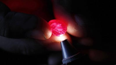 A ruby cutter inspects a ruby in Mogok. Myanmar rubies are preferred for their clarity and quality, particularly those with the 'Pigeon's Blood' hue. Soe Zeya Tun / Reuters