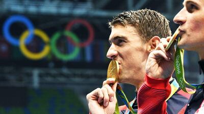 Michael Phelps of the USA poses with his gold medal after his team's victory in the men's 4x200m freestyle relay at the 2016 Rio Olympics. Bernd Thissen / EPA / August 9, 2016