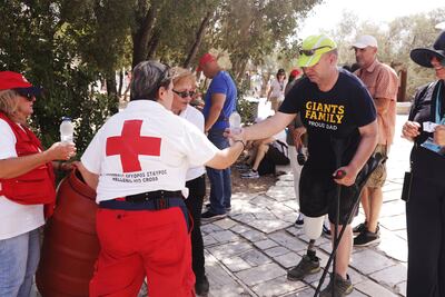 A Red Cross volunteer gives water to visitors near the Acropolis hill. Reuters
