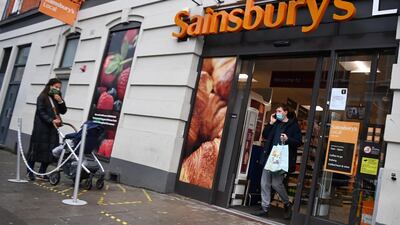 A customer exits a Sainsbury's supermarket in London. EPA
