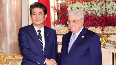 Mr Abe, left, shakes hands with Palestinian President Mahmoud Abbas during a meeting at the State Guesthouse. AP