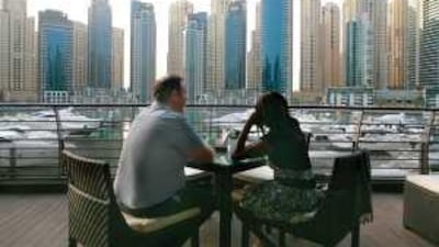 Bob Parsons, 54, from the UK, and Grace Macharia, 38, from Kenya, sit on the patio of Aquara Restaurant at the Dubai Marina Yacht Club.