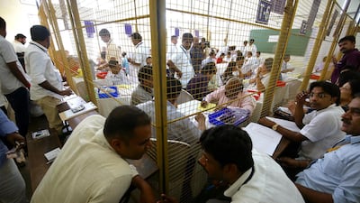Indian election officials tally votes from electronic voting machines at counting centre in Bengaluru. EPA