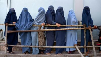 In this photo taken on June 12, 2018, Afghan burqa-clad women stands as they wait to receive food donated by a private charity during the Islamic holy month of Ramadan, in Mazar-i-Sharif. Muslims throughout the world are marking the month of Ramadan, the holiest month in the Islamic calendar during which devotees fast from dawn till dus. / AFP / FARSHAD USYAN