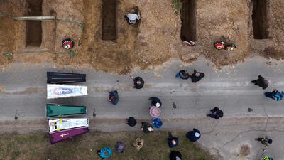 The bodies of four people who died during the Russian occupation await burial during funerals in Bucha, Ukraine, last month. AP Photo