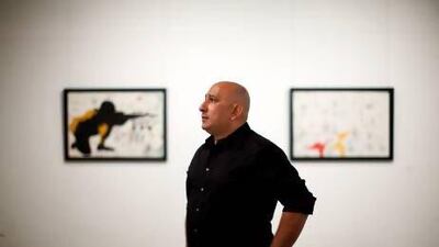 Khaled Hafez takes in his exhibition, which includes the painting Tomb Sonata in Three Military Movements. Christopher Pike / The National