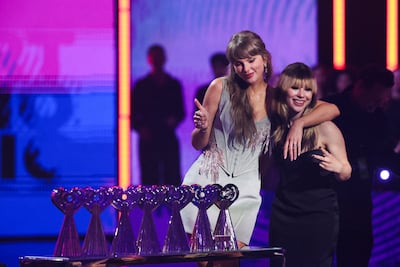 Swift accepts the Artist of the Year award from Alysa Liu at the 2026 iHeartRadio Music Awards. Reuters