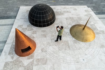 'A point in time (2021)' by Khalil Rabah, featuring enlarged 11th century implements for determining location. A small black circle below the gold-coloured spindle shows Dubai on the map the objects create. Photo: Thorsten Arendt; Khalil Rabah