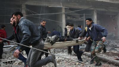 Syrian rescuers evacuate badly injured people following regime strikes on the besieged rebel-held enclave of Kafr Batna near Damascus. Amer Almohibany / AFP