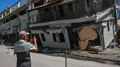 A man takes a photo of a collapsed building after a 7. 8 magnitude earthquake in General Santos City on June 9, 2026. A 7. 8-magnitude earthquake in the southern Philippines on June 8 killed at least 35 people, according to provincial authorities, after toppling buildings and sparking tsunami warnings across the region. (Photo by Jam STA ROSA / AFP)