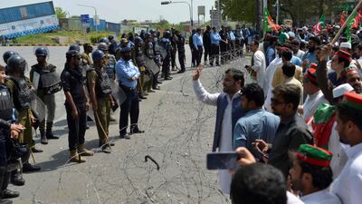 Policemen stand guard as activists of the ruling Pakistani Tehreek-e-Insaf (PTI) party protest in Islamabad after the country’s president dissolved the National Assembly on the advice of Prime Minister Imran Khan. AFP