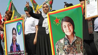 Kurds hold photos of slain Kurdish politician Hevrin Khalaf, left, and Kurdish fighter Sehid Rojinda Qendil, at a protest in Beirut on October 13, 2019 against Turkey's Syria offensive. AFP