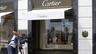 A journalist taking pictures in front of the Cartier jewellery shop on the Croisette in Cannes, French Riviera, on May 5, 2015, after the hold up by four armed men who fled with a large amount of jewelry. Valery Hache/AFP Photo
