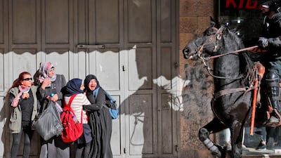 Palestinian women react as an Israeli mounted policeman disperses protesters in Jerusalem.. Ahmad Gharabli / AFp