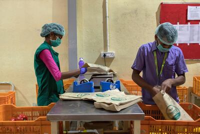 Workers bag and weigh bananas and red peppers at a warehouse of Bigbasket. Samyukta Lakshmi/Bloomberg