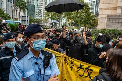 HONG KONG, HONG KONG - MARCH 1: Pro-democracy supporters line up outside the West Kowloon court as police officers patrol on March 1, 2021 in Hong Kong. The protest took place during the court appearances by dozens of dissidents charged with subversion in the largest use of Beijing's sweeping new the national security law to date. (Photo by Anthony Kwan/Getty Images)