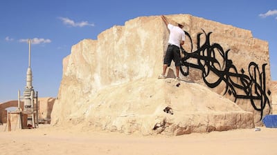 The artist eL Seed painting at the old Star Wars movie set in Tunisia. Courtesy El Seed