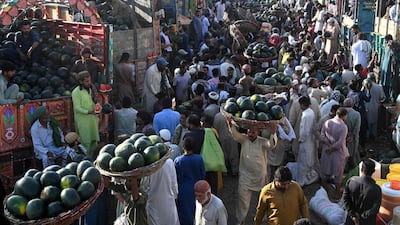 Farmers and vendors wait for customers at a wholesale market in Lahore, Pakistan. AFP