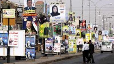 Campaign posters line the streets in Basra ahead of the election. The poverty of the region, however, is driving voters more than policies.