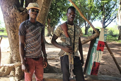 Suleiman Abossa, right, a rebel soldier with the FPRC armed group, stands at a checkpoint on the main road from N’Dele, in the same region where Djidah recruited his militants