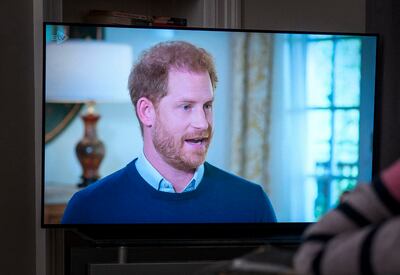 A person at home watches Prince Harry being interviewed by ITV's Tom Bradby. PA