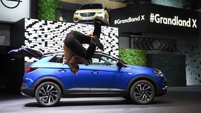 A parkour runner jumps for joy in front of the Opel Grandland X cross-over. Arne Dedert / dpa via AP