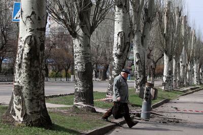 A man walks past an unexploded tail section of a 300mm rocket which appeared to contain cluster bombs after shelling in Ukraine's Lugansk region. AFP