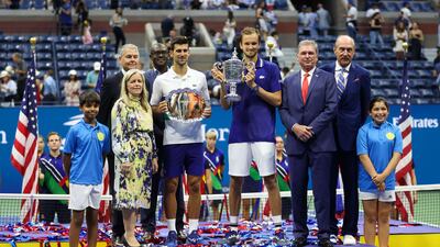 Novak Djokovic of Serbia holds the runner-up trophy alongside Daniil Medvedev of Russia who celebrates with the championship trophy at the USTA Billie Jean King National Tennis Center on September 12, 2021. AFP