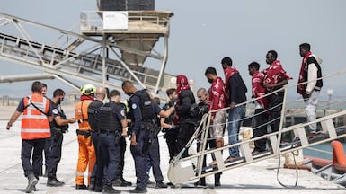 Passengers from the boat that caught fire disembark from a coastguard ship in Boulogne, France. AFP