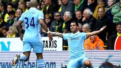 Carlos Tevez, right, the Manchester City forward, celebrates scoring the opening goal against Norwich City with teammate Nigel de Jong at Carrow Road. Matthew Lewis / Getty Images