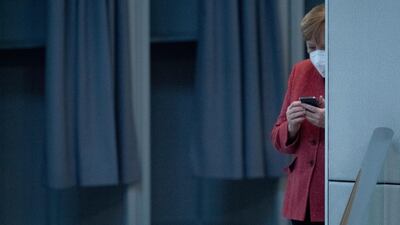 German Chancellor Angela Merkel uses her mobile device at the parliament Bundestag in Berlin. AP Photo