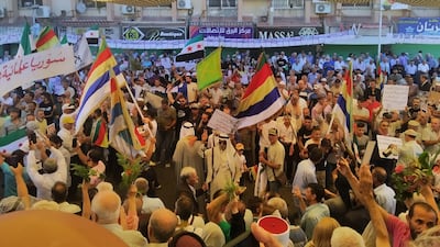 Demonstrators wave the Druze flag in the centre of the southern Syrian city of Suweida, on August 16, 2022, at the one year anniversary of the protest movement against President Bashar Al Assad in the area. Photo: Suhail Thubian.