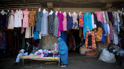 An Afghan woman shops for clothing.