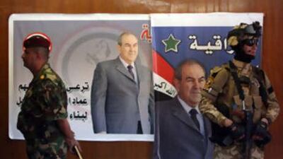 Iraqi army soldiers stand guard near posters for Ayad Allawi, the Iraqiyya leader, in Baghdad. Mr Allawi ended in a virtual tie with the prime minister, Nouri al Maliki.