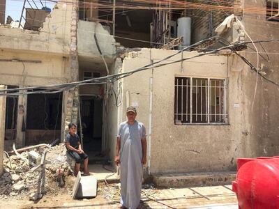 Hussein Abbas, 46, stands in front of his home. The second floor of the building was damaged in the explosion. Sofia Barbarani / The National