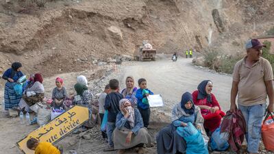 People displaced by the earthquake sit with their belongings by the side of the road between Marrakesh and Taroudant in the Atlas mountains. AFP