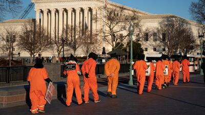 Outside the Supreme Court in Washington, a group of people dressed as prisoners protest against the Guantanamo Bay prison. Reuters